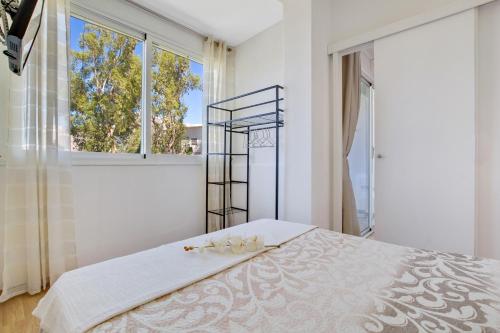 - une chambre blanche avec un lit et une fenêtre dans l'établissement Bellamar By IVI Real Estate, à Torremolinos