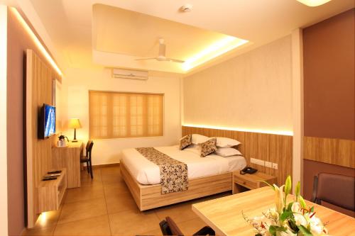 a hotel room with a bed and a table at Hotel Luciya Palace in Trichūr