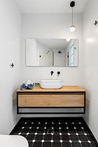 a bathroom with a sink and a black and white floor at Sunsets Paradise 2BR with Parking by Beachfront Stay in Herzelia 