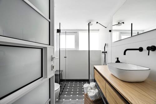 a bathroom with a white tub and a sink at Sunsets Paradise 2BR with Parking by Beachfront Stay in Herzelia 