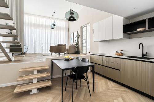 a kitchen with white cabinets and a black table at Sunsets Paradise 2BR with Parking by Beachfront Stay in Herzelia 