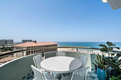 a table and chairs on a balcony with the beach at Sunsets Paradise 2BR with Parking by Beachfront Stay in Herzelia 