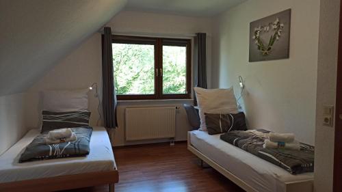 2 Betten in einem Zimmer mit Fenster in der Unterkunft Wohnung mit Spielplatz, Kaninchen und Whirlpool in Grafenhausen