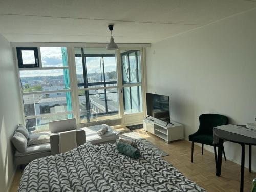 een slaapkamer met een bed, een televisie en een bureau bij Modern and Cozy apartment with Sauna2 in Espoo