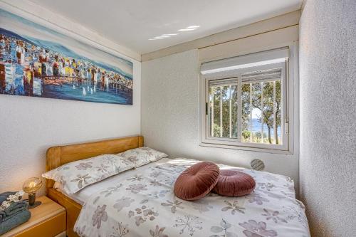 1 dormitorio con 1 cama con 2 almohadas en Cottage on the Kavran Beach, en Kavran