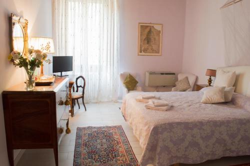 a bedroom with a bed and a desk and a television at La Rosa Townhouse in Florence