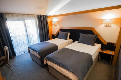 a hotel room with two beds and a window at Roof 264 Hotel & Suites in Sakarya