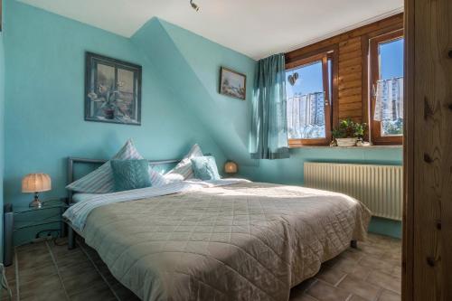 1 dormitorio con 1 cama con paredes y ventanas azules en Ferienwohnung am Ps Speicher 