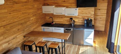 a kitchen in a tiny house with a table and stools at IDEA Wypoczynek Domek Jezioro Białe in Okuninka
