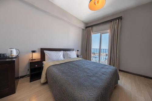 a bedroom with a bed and a large window at Kyrenia British Harbour Hotel in Kérynia