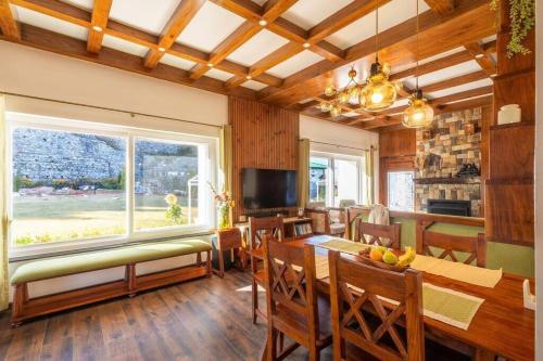 a dining room with a table and a large window at A Luxurious Mountain Bungalow with stunning views in Dhanaulti