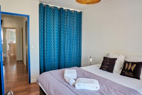 Schlafzimmer mit einem Bett mit blauem Akzent in der Unterkunft Appartement cosy proche Paris et Stade de France in Saint-Denis