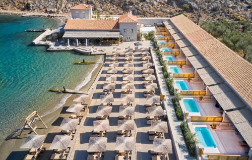 an aerial view of a resort with umbrellas and the water at Mandraki Beach Resort in Mandraki