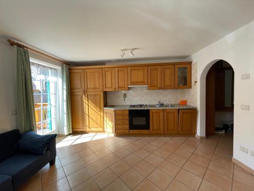 a kitchen with wooden cabinets and a blue couch at Casa Cesarina by AMA Val di Fassa in Canazei