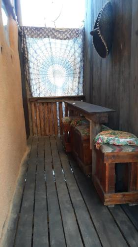a room with a table and benches and a window at Chales sprinfeld in Paraty