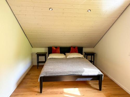 a bed with red pillows in a attic at Traumferienhaus Leimbach am Nürburgring in Leimbach
