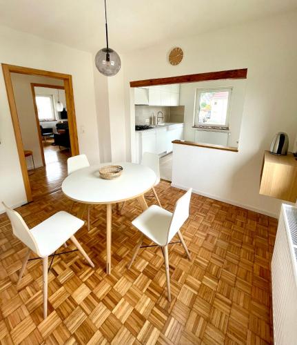 a living room with a table and chairs and a kitchen at A14 Three Bed Apartment City Center in Heidenheim an der Brenz
