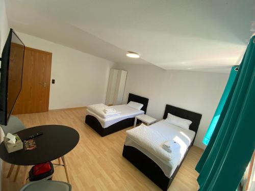 um pequeno quarto com duas camas e uma mesa em RS Zimmervermietung em Zülpich