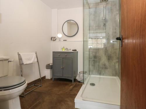 a bathroom with a shower and a toilet and a sink at Foggs Barn in Leek