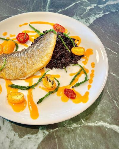 a plate of food with a fish and vegetables at Ambasciatori Hotel Venice Mestre, Tapestry Collection by Hilton in Mestre