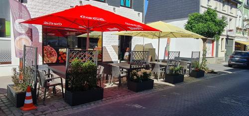 a restaurant with tables and umbrellas on a street at RS Zimmervermietung in Zülpich