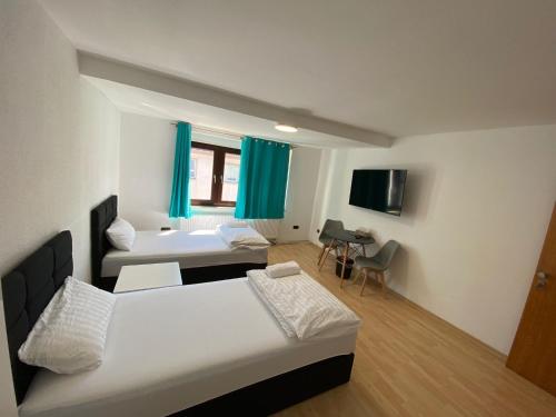 um quarto de hotel com duas camas e uma televisão em RS Zimmervermietung em Zülpich