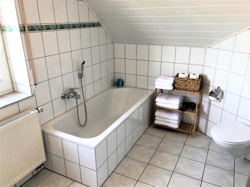 a white bathroom with a tub and a toilet at Apartment-Regner in Weidenberg