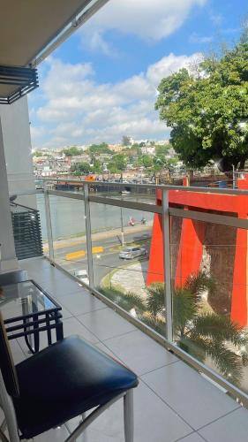 a balcony with a glass table and a view of a street at Apartamento de 3 habitaciones en zona colonial frente al ozama in Calero