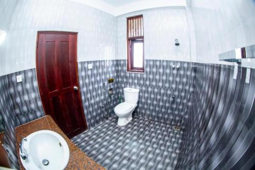y baño con aseo y lavamanos. en Hotel Blue Bird en Negombo