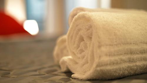 a stack of towels sitting on top of a bed at LE TORRI Loft Apartment in Fossano