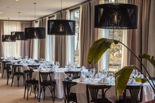 Un comedor con mesas y sillas blancas y candelabros. en Amérian Aluminé, en Aluminé