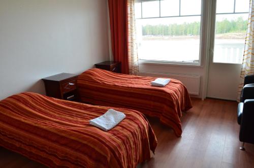 a hotel room with two beds and a window at Hotel Reima Country Center in Jämijärvi