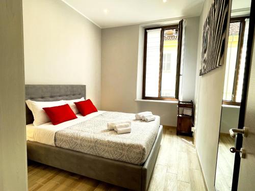 a bedroom with a bed with red pillows on it at LE TORRI Loft Apartment in Fossano