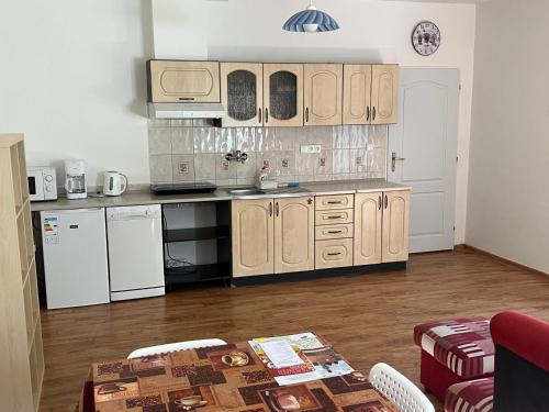 eine Küche mit Holzschränken und einem Tisch im Zimmer in der Unterkunft Apartmán v Zahradní in Prachatice