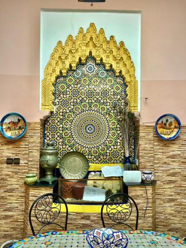 uma parede com uma pintura com duas cadeiras em Dar Ibrahim em Rabat