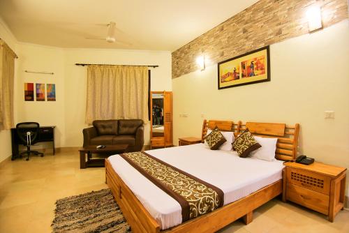 a bedroom with a bed and a couch and a chair at BedChambers Serviced Apartments, Sushant Lok in Gurgaon