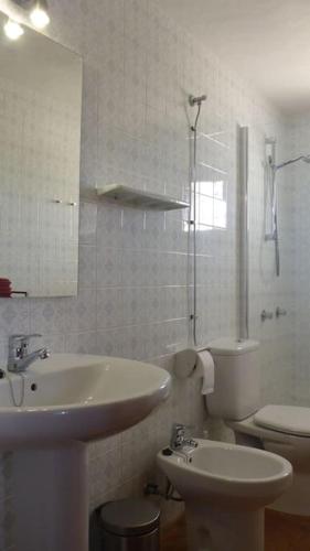 a bathroom with a sink and a toilet and a mirror at Finca Roja Formentera in Sant Francesc Xavier