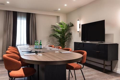 a conference room with a table with chairs and a flat screen tv at Ambasciatori Hotel Venice Mestre, Tapestry Collection by Hilton in Mestre