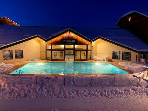 une piscine couverte de neige devant un bâtiment dans l'établissement T2 + coin montagne - Wifi/Piscine - Les Orres 1800, aux Orres