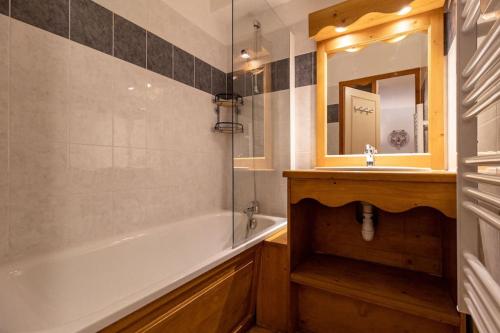 un bagno con vasca, lavandino e specchio di T2 + coin montagne - Wifi/Piscine - Les Orres 1800 a Les Orres