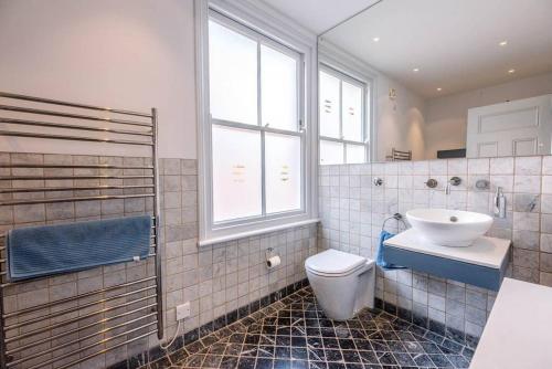 a bathroom with a sink and a toilet and a window at 6 The Terrace, Walberswick in Southwold