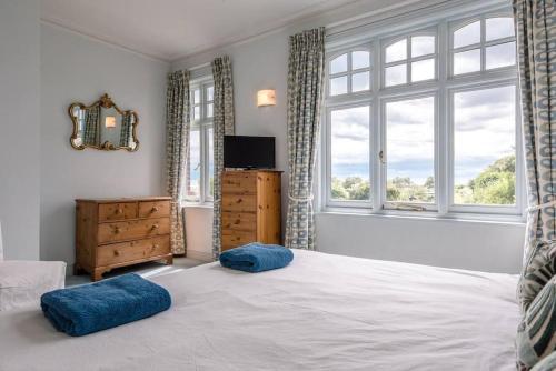 a bedroom with a bed with two blue pillows on it at 6 The Terrace, Walberswick in Southwold