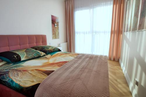 a bedroom with a large bed with a large window at Apartament BOTANIQ #free parking in Bydgoszcz