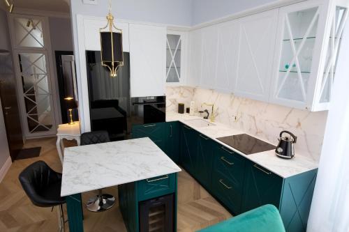 a kitchen with green cabinets and a white counter top at Apartament BOTANIQ #free parking in Bydgoszcz