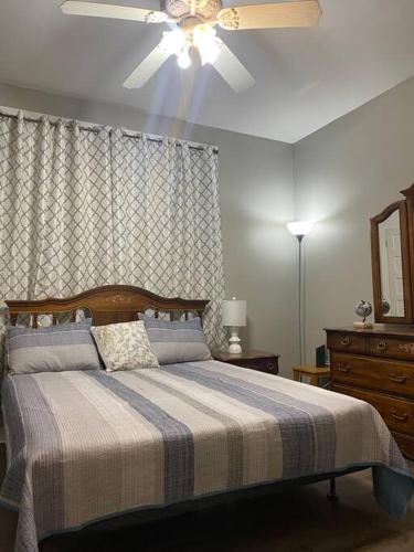 a bedroom with a bed with a ceiling fan at Quiet & Beautiful Country Home in Baker