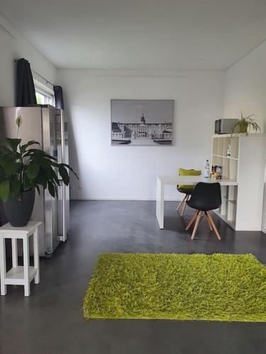 una sala de estar con una alfombra verde y una mesa en Moderne 2 Zimmerwohnung/ Eggenstein/nähe KIT Nord, en Eggenstein-Leopoldshafen