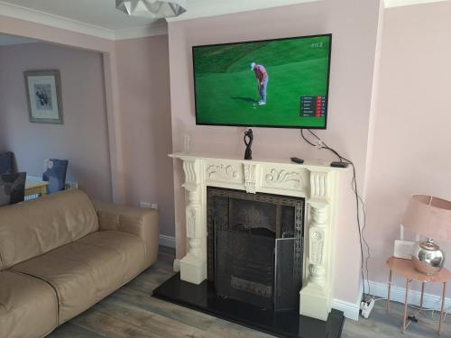 a living room with a fireplace with a tv above it at 3 Riverwalk, Wicklow Town in Wicklow