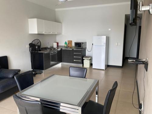 cocina y sala de estar con mesa y nevera en Best Of Xlendi SeaFront Apartments, en Xlendi