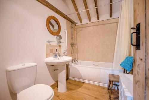 uma casa de banho com um WC, um lavatório e uma banheira em Long Barn, Wrentham em Beccles