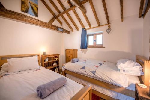 um quarto com 2 camas e uma janela em Long Barn, Wrentham em Beccles